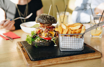 Close-up of burger with french fries served on table in restaurant