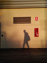 Shadow of man walking on illuminated road