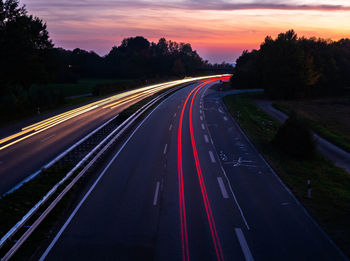 Light trails on highway at sunset