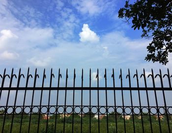 Low angle view of fence on field against sky