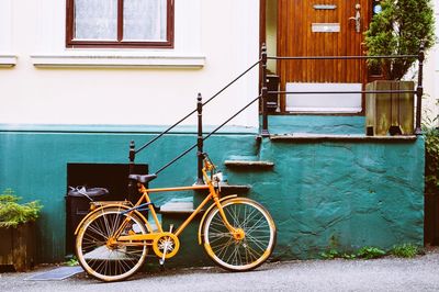 Bicycle leaning parked against brick wall