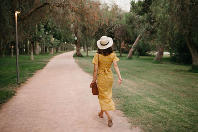 Rear view of woman walking on footpath