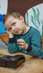 Close-up of boy looking away while sitting on table