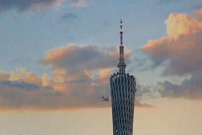 Low angle view of communications tower against sky during sunset