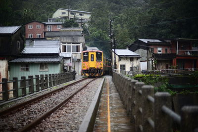 Train on railroad tracks in city against sky
