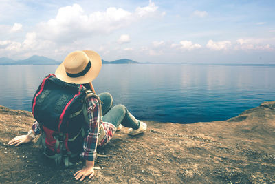 Rear view of man looking at sea against sky