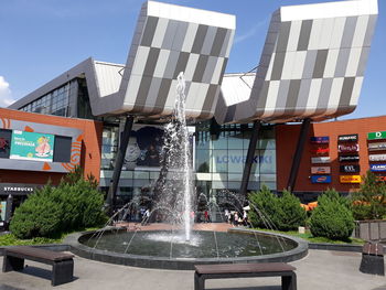 Fountain in city against sky