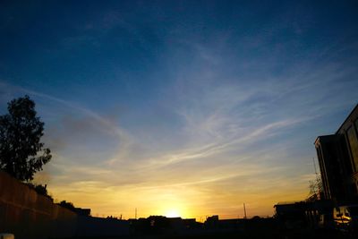 Low angle view of silhouette buildings against sky at sunset