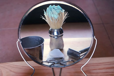 Reflection of shaving equipment on mirror in bathroom