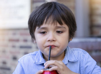 Close-up of cute boy drinking soda
