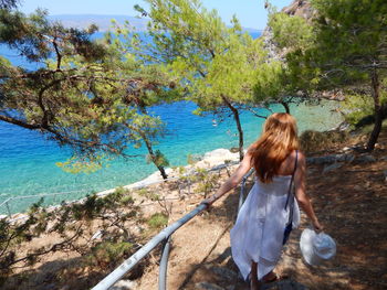 High angle view of girl walking towards river on sunny day