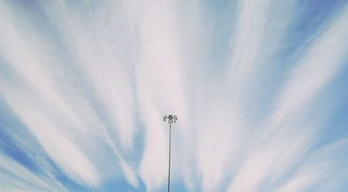 Low angle view of floodlight against cloudy sky