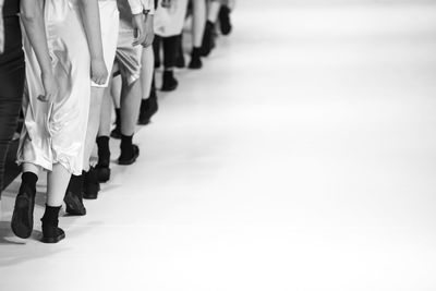 Low section of fashion models walking on runway