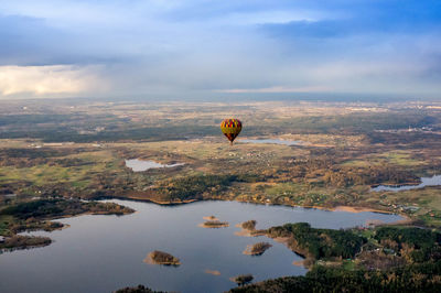 Hot air balloon flying over water against sky