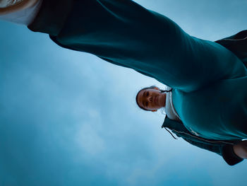 Low angle view of people on blue sky