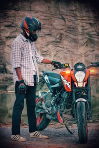 Man standing on motor scooter