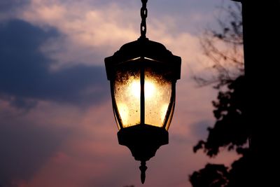 Low angle view of illuminated street light against sky at sunset