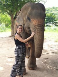 Full length of woman by elephant in zoo
