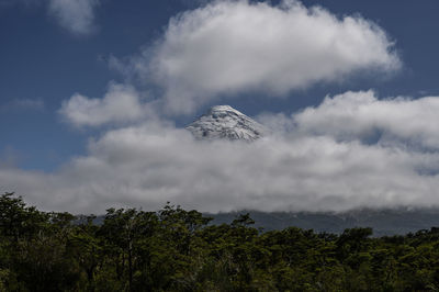 Low angle view of wind turbines on mountain against sky