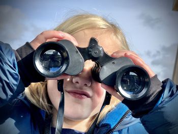 Close-up of girl looking through binoculars