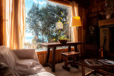 Interior of a cozy and relaxing cabin, with sunlight from the window that sees to the forest