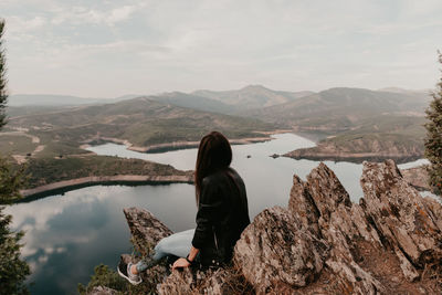 Rear view of woman looking at mountain against sky