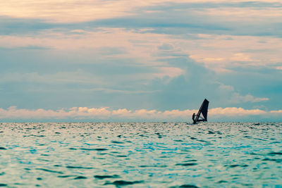 Man surfing in sea against sky