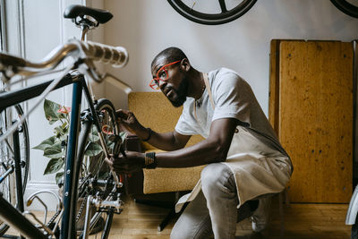 Male owner repairing bicycle in workshop