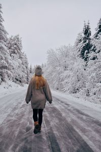 Rear view of woman walking on snow