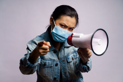 Portrait of young woman standing against white background