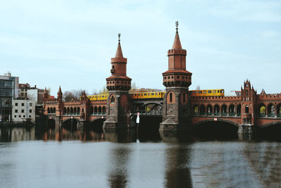 Arch bridge over river against buildings in city