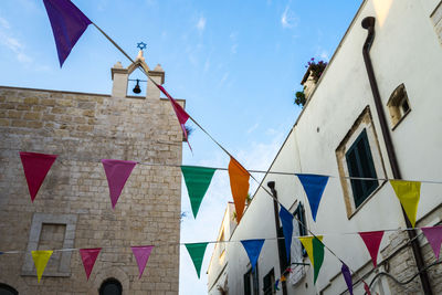 Low angle view of flags hanging against buildings