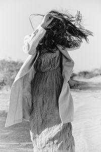 Rear view of woman standing at beach