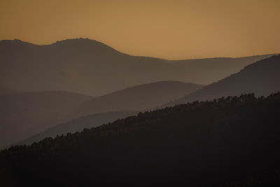 Scenic view of silhouette mountains against sky during sunset