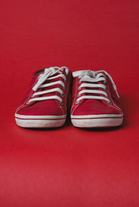 Close-up of shoes against red background