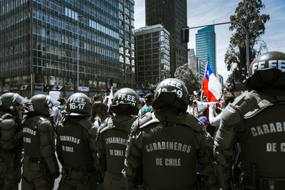 Rear view of people on street amidst buildings in city