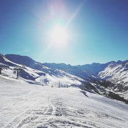 Scenic view of snowcapped mountains against sky on sunny day