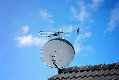 Low angle view of communications tower against blue sky