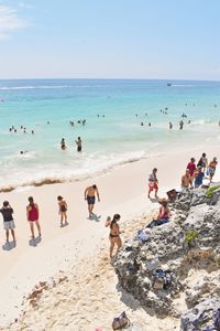 People at beach against clear sky