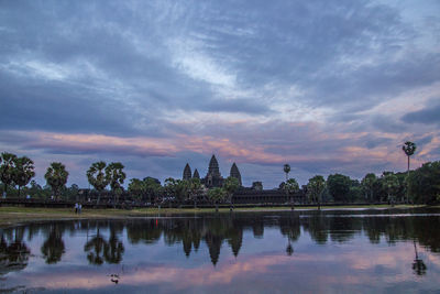 Reflection of trees in lake at sunset