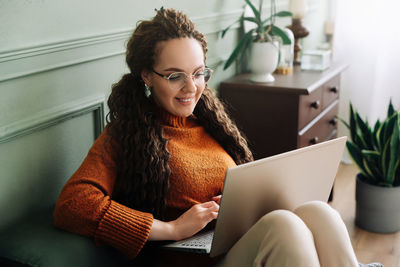 Young woman using laptop at home