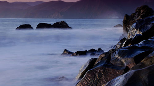 Scenic view of rocks in sea against sky