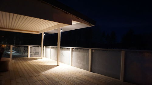 Empty footpath against wall at night