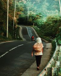 Rear view of woman standing on tree