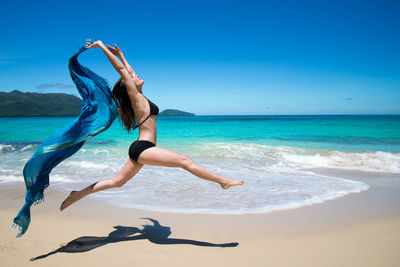 Girl dancing with scarf on beach