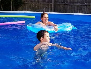 Siblings enjoying in wading pool