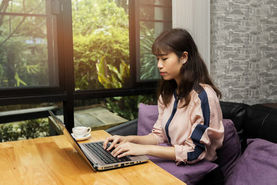 Young woman using laptop at home