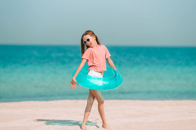 Woman standing on beach against sea