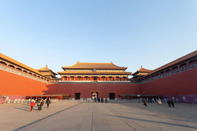 Group of people in building against clear sky