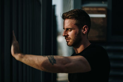 Side view of young man looking through camera